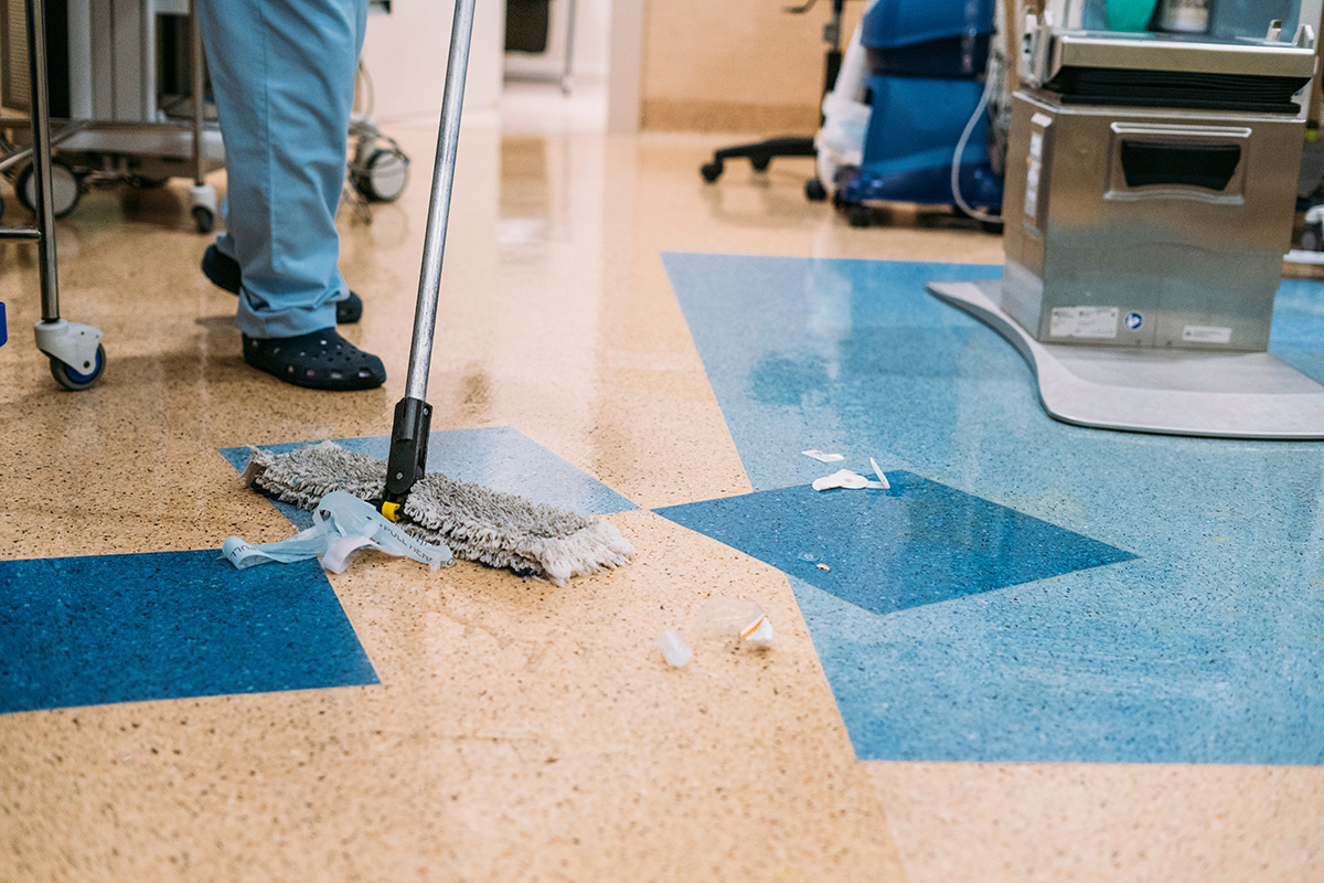 A person cleaning a contaminated hospital floor.